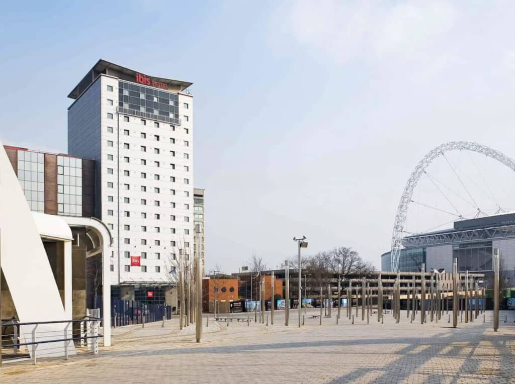 Hotellet utenfor med gater, blå himmel og bygninger.