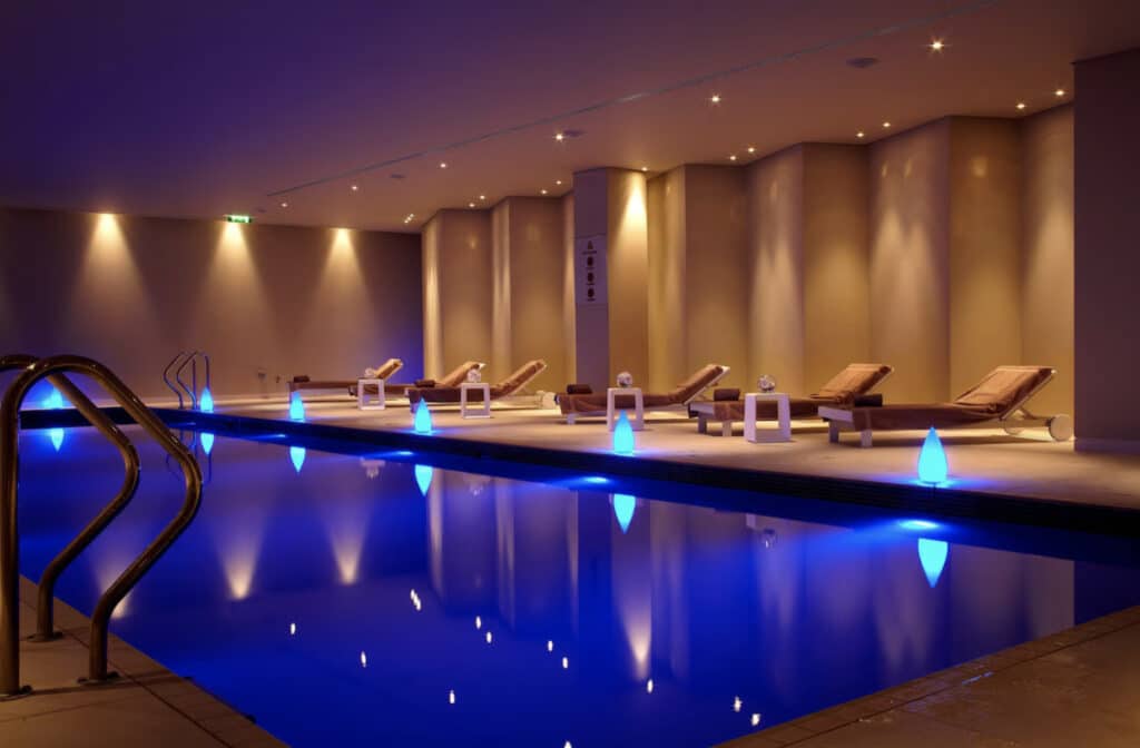 Hotellbasseng med solsenger inne.