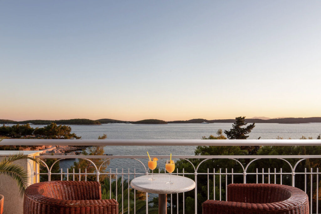 Hotell med balkong og utsikt over vannet.