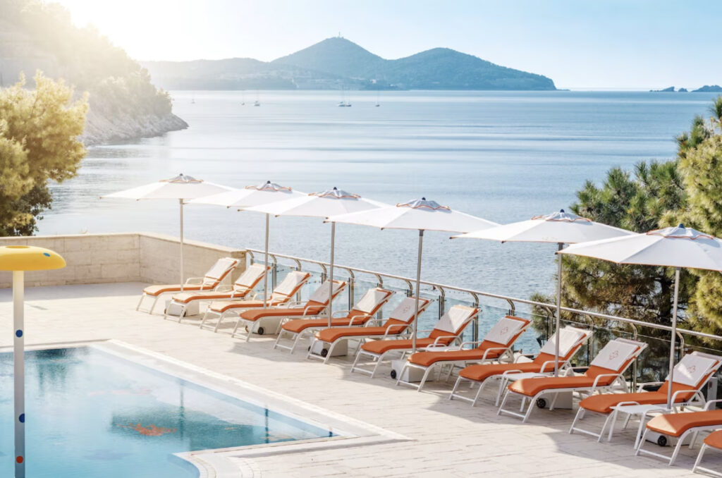 Hotell med basseng og utsikt over vannet.
