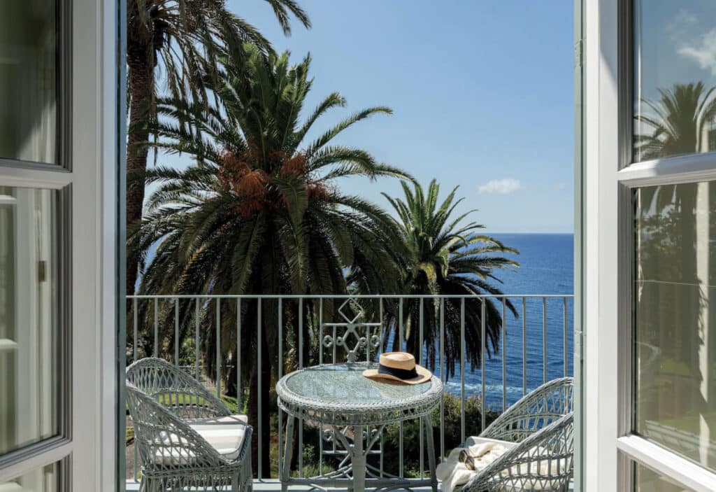 Balkong med palme og sitteplass. 