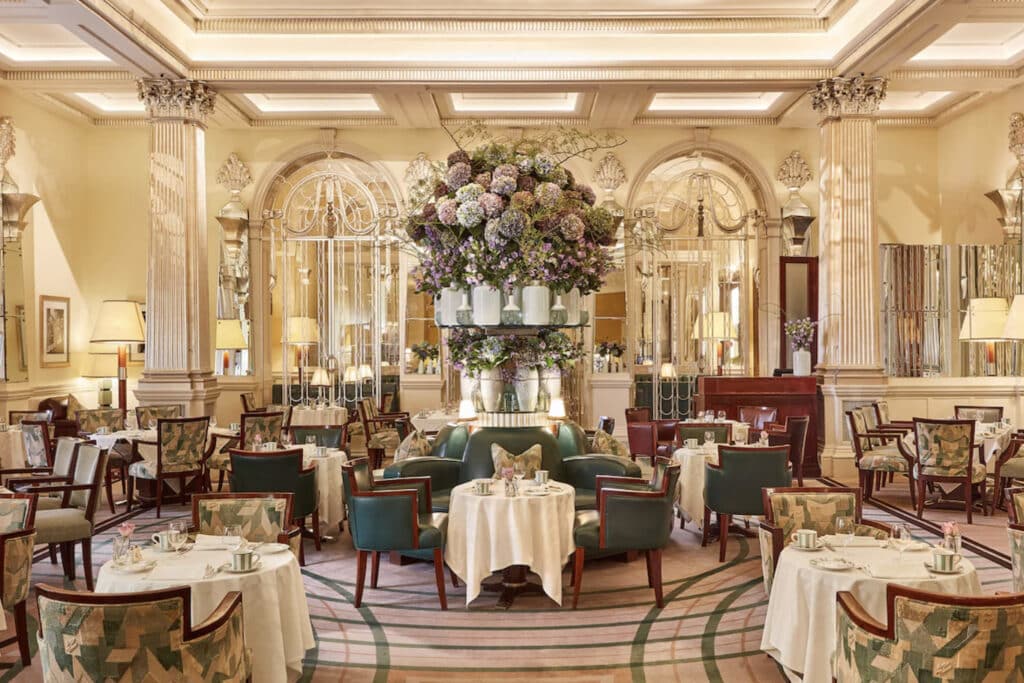 Hotellrestaurant med bord og elegante duker og store blomster. lokalene. 