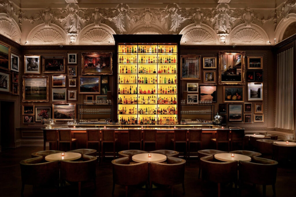 Hotellbar med stoler og bilder på veggene.