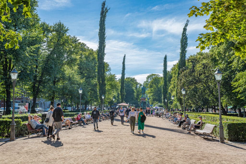En grønn park med mennesker som går gjennom.