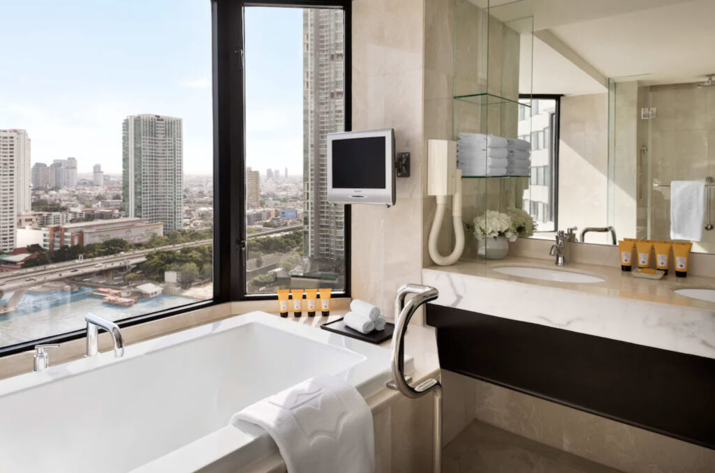 Hotellbad på rommet med utsikt over skyskrapere. 