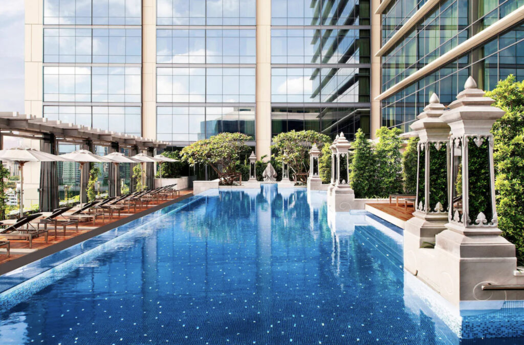 Utendørs hotellbasseng med solsenger. 