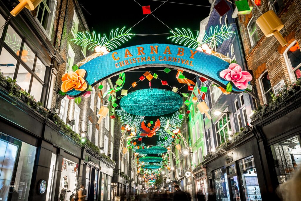 Carnaby street med skilt over som viser at det er festival i gatene. Julelys og pynt over gaten.