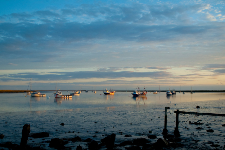 fishing boats moored in a tidal estuary at sunset
