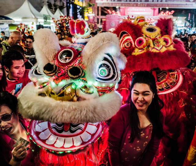 Bangkok, Thailand - February 8, 2016: Crowd and people posing beside lion dancers during the celebration of the chinese New Year at Yaowarat Road in Chinatown Bangkok Thailand