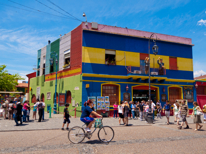 Colourful building in the famous district of La Bocca in Buenos Aires - many people can be seen on the street, including some street performers.