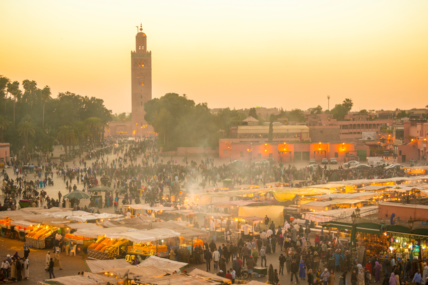 Djemaa el Fna at dusk, Marrakech, Morocco, North Africa. Large crowds ofpeople gather around food stalls, fruit juice stands and performers in this ancient world heritage site at centre of the warm and dusty medina in Marrakesh.