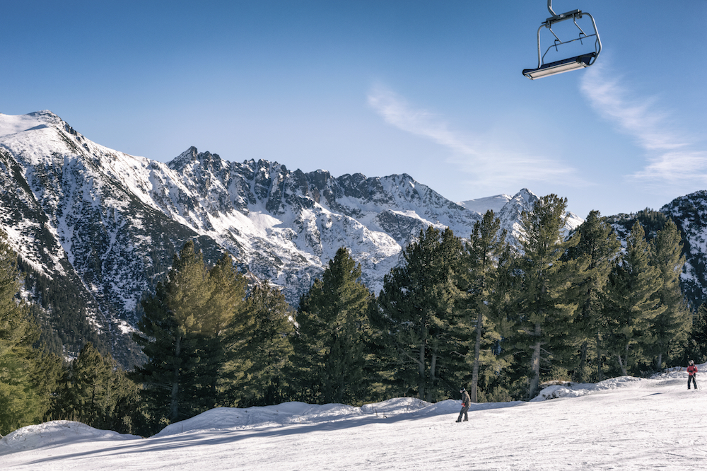 Ski slope with chair lift and winter mountains panorama., resort Bansko, Bulgaria