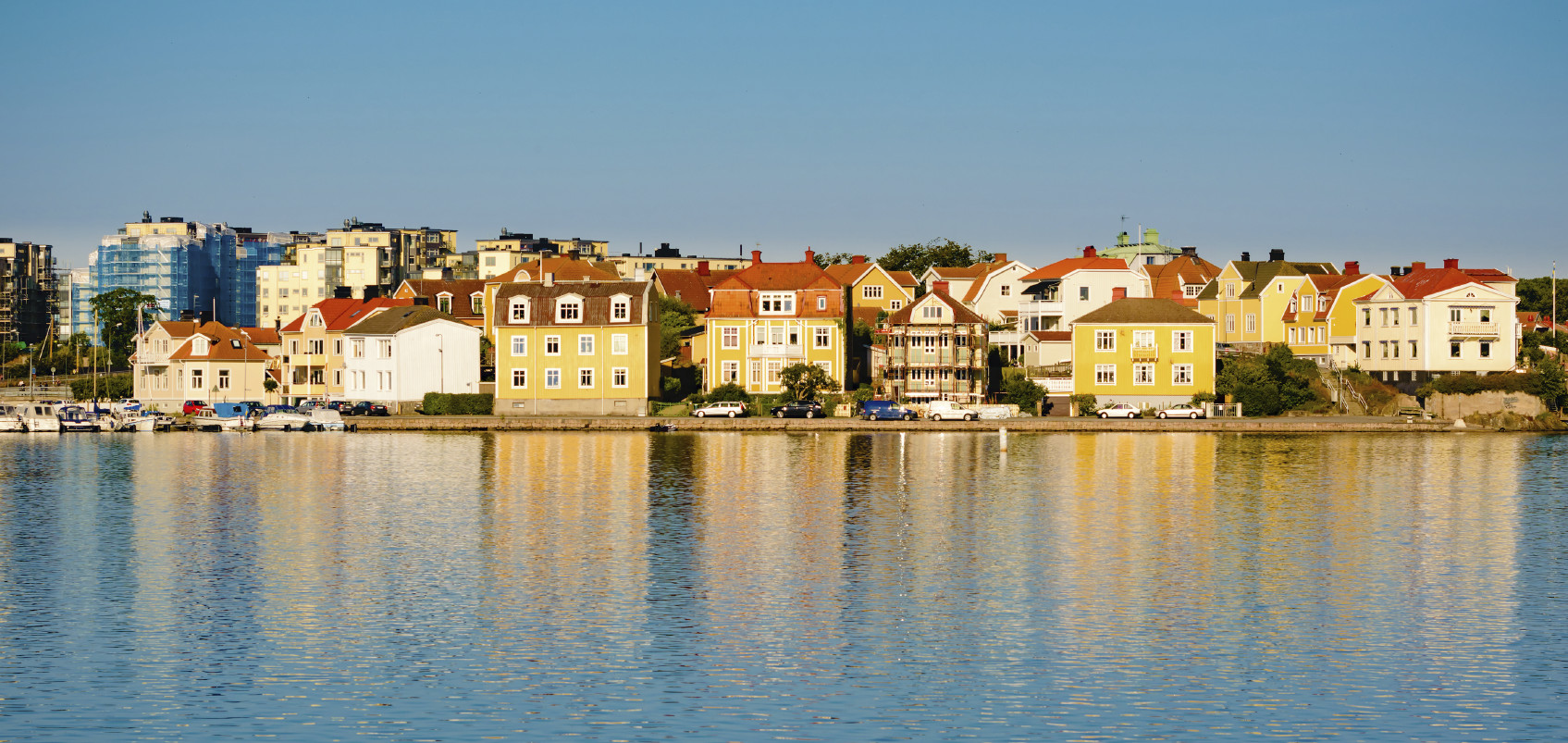 One of the islands that make up the city of Karlskrona. Houses are close to water and they cast fine reflections in the sea. Fine urban landscape. Copyspace in water.