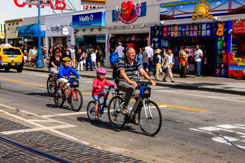 San Francisco, CA, USA - July 7, 2015: Family riding their bicycles along Jefferson Street in San Francisco CA