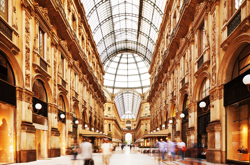 Shot of the famous Galleria Vittorio Emanuele II in Milano, Italy, showing the spectacular view of an almost golden gate to luxury. Long exposure for motion blurred people rushing through.