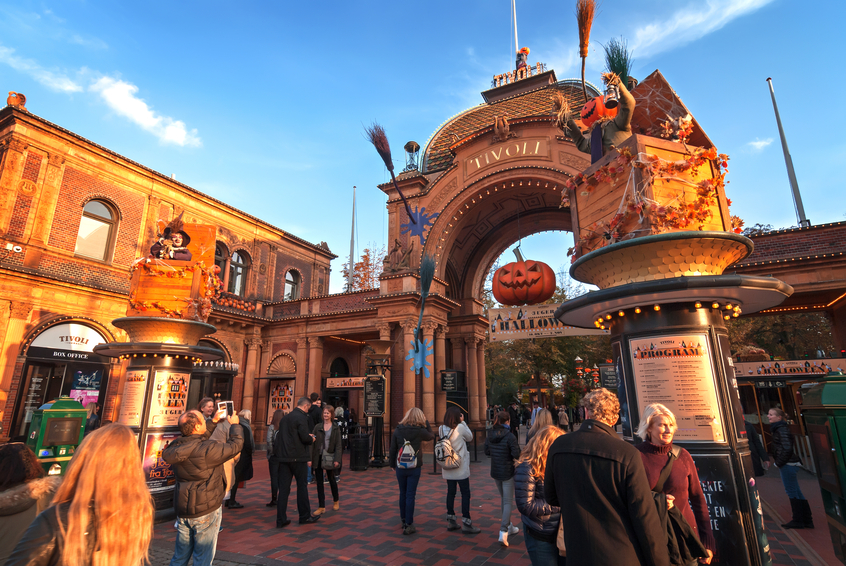 Copenhagen, Denmark, october 10, 2014: Entrance to Tivoli Gardens in Copenhagen. Tourist are making photos in front of beautiful entrance. It is a famous amusement park and pleasure garden in Copenhagen. This picture was shot on Halloween. The park opened on 1843 and is the second oldest amusement park in the world and the fourth most visited in Europe.