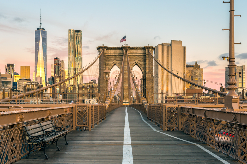 The Famous Brooklyn Bridge at Sunrise, New York City, USA. The sun is rising over Brooklyn on this beautiful day of Autumn