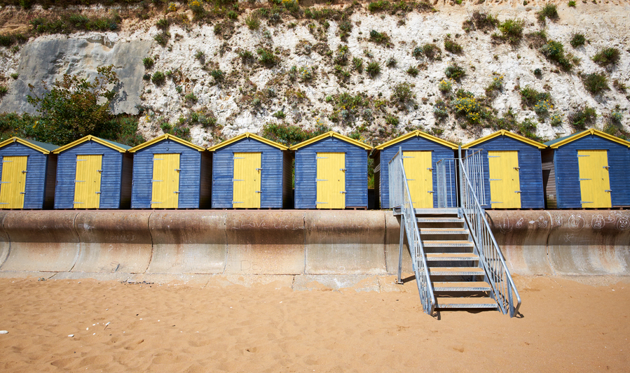 A line of blue and yellow beach huts in Broadstairs, Kent.