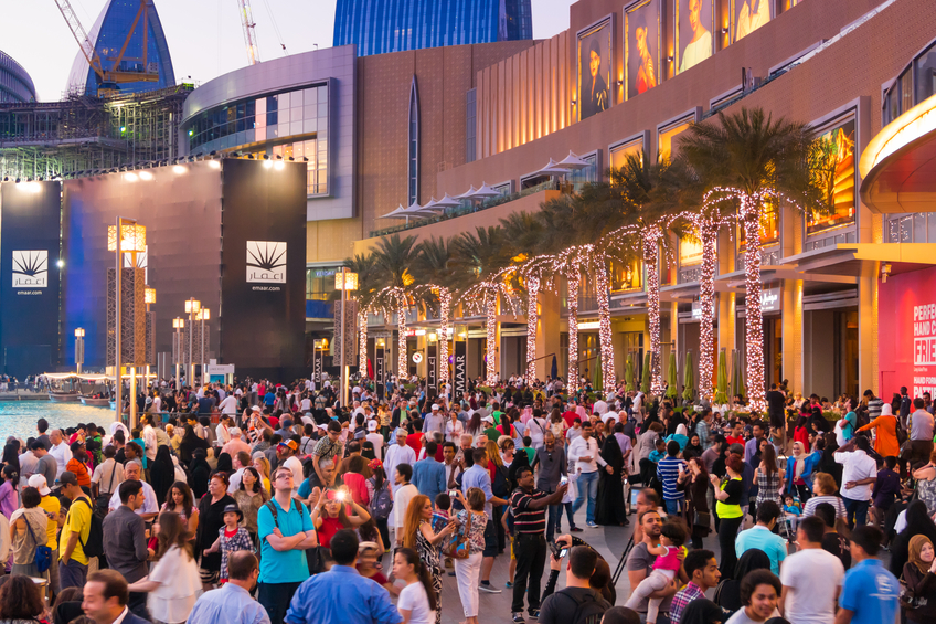 Dubai, UAE- March 25, 2015: Outside the Dubai Shopping Mall - crowds, at sunset.The Dubai Mall contains more than 1,200 shops iStockalypse Dubai - UAE 2015