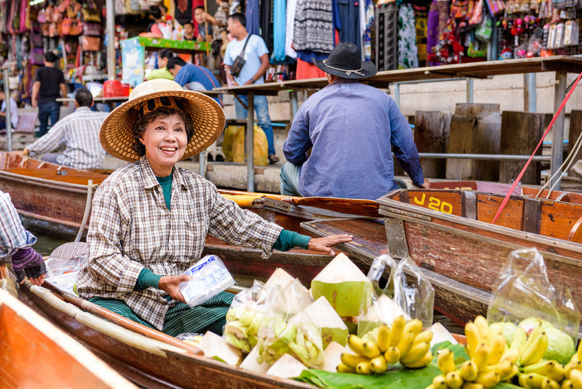 Kanchanaburi, Thailand- October 7, 2015: A merchant sales her food goods at the Damnoen Saduak Floating Market outside of Bangkok.