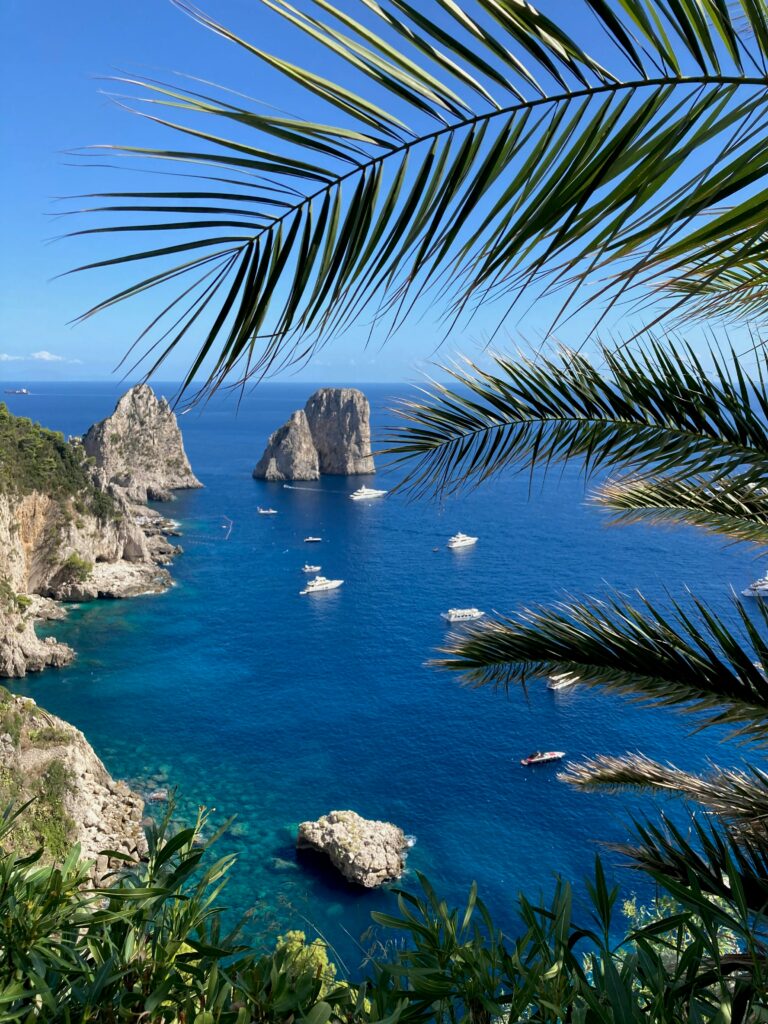 Il Faraglioni i Italia på Capri. Grønt landskap, hav og vakre øy. Bli med på ferie i Napolibukta.
