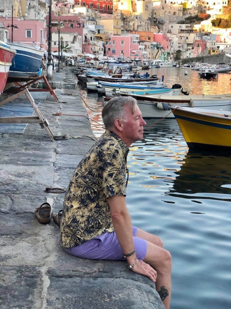 Erik Valebrokk nyter utsikten over havnen på Procida i Italia. Bli med på ferie i Napolibukta.