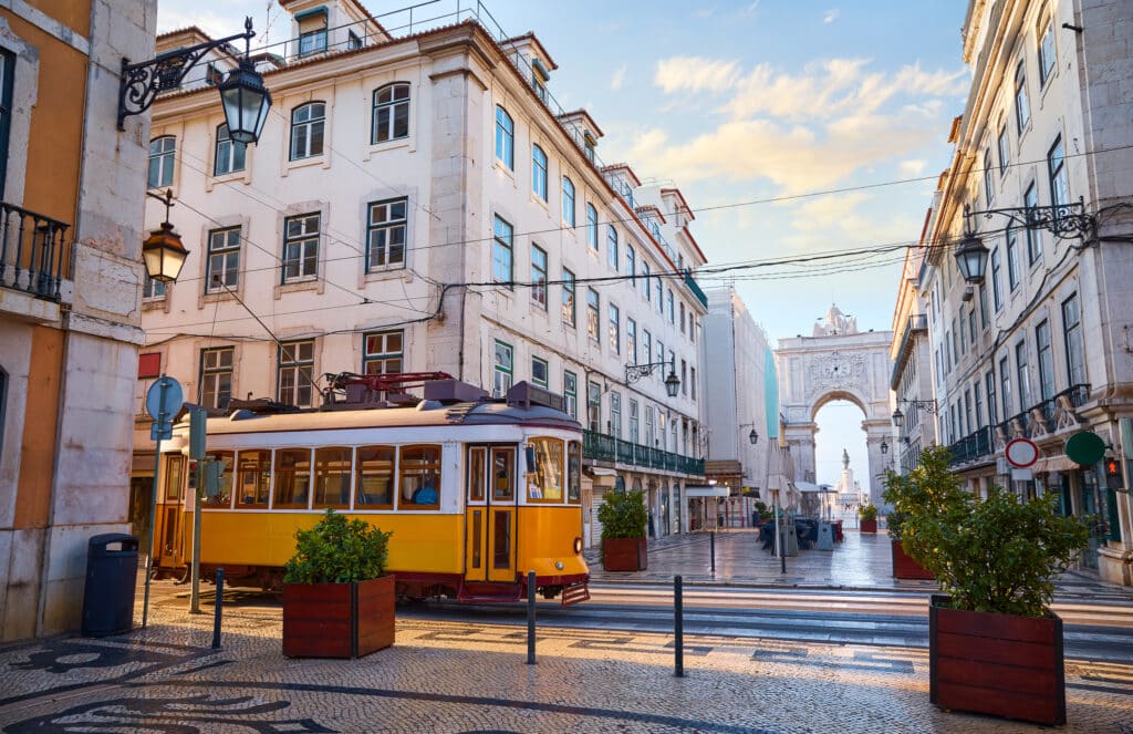 Lisboa med gul trikk og gater.