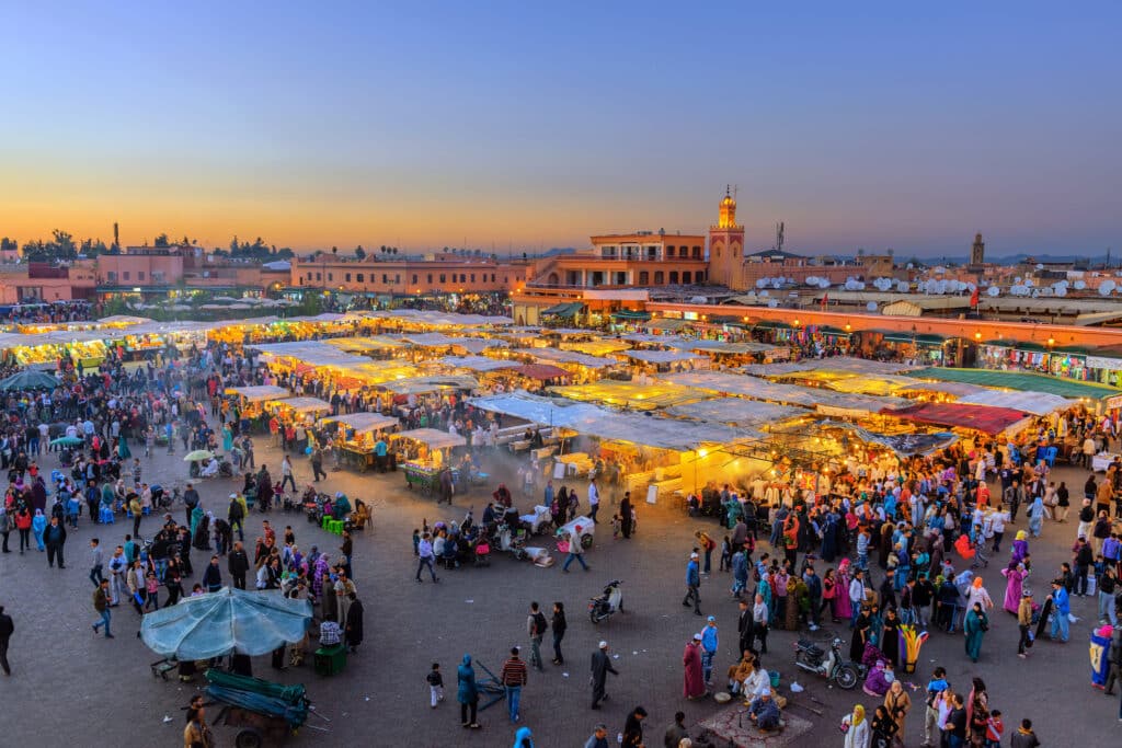 Matmarkedstorg i Marrakesh. Livlige farger med folk.