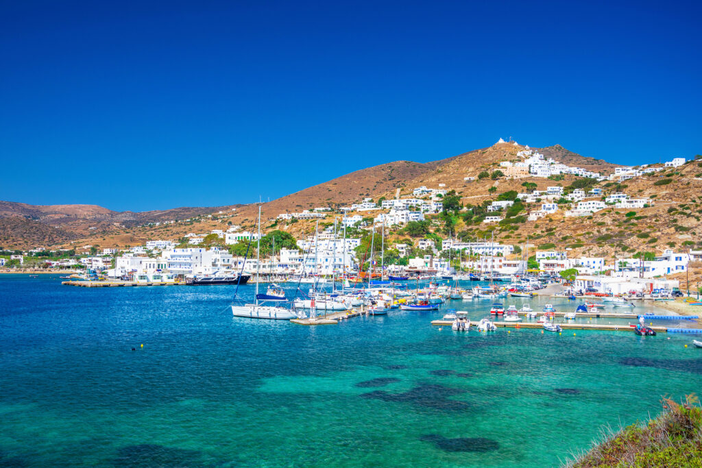 Hellas. øy med båter, havn og turkist vann.