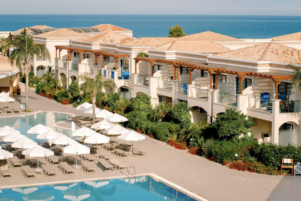 Hotell Mythos Beach i Rhodos. Flott hotell med parasoller og basseng.