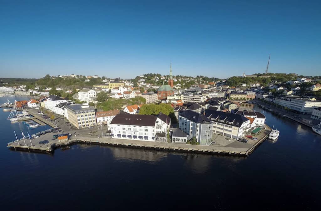 Hotellfasade med blå himmel oh andre bygninger i nærheten.