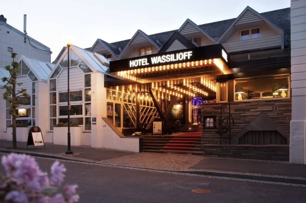 Hotellfasaden til Wassilioff. Trapper opp, nesten kveld. Blomster på sidegaten.