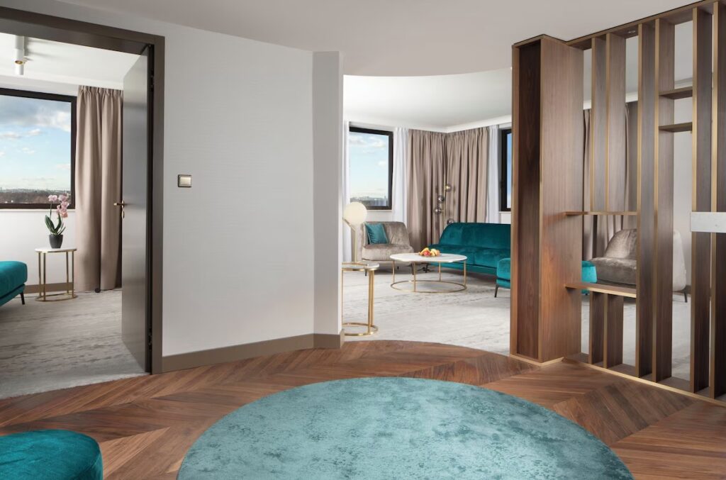 suite på et hotell i praha som viser turkist teppe på gulvet, sovesofa og interiør