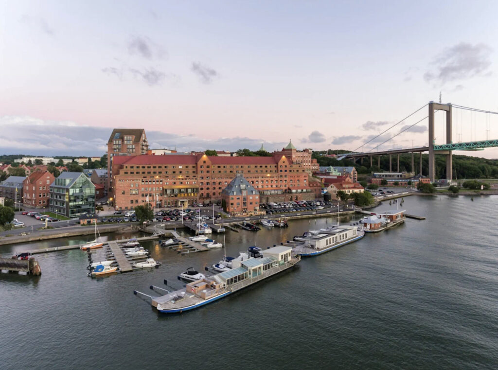 Hotellet rett ved havnen med båt og bro.