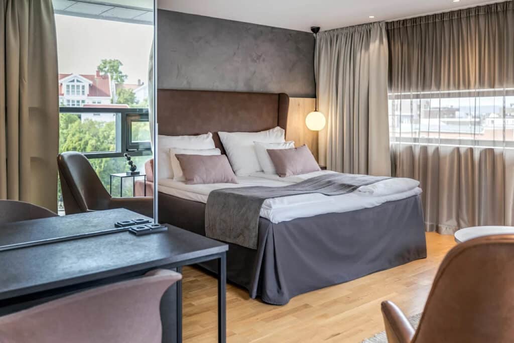 Hotellrom med dobbeltseng og speil.