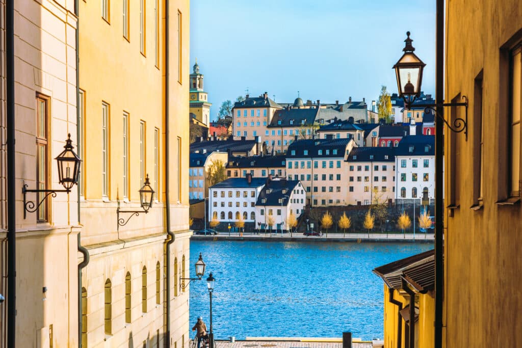 En trang gate som går ned mot vannet med hus i bakgrunnen.