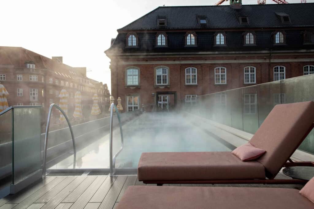 Hotell med basseng på taket og to solsenger.