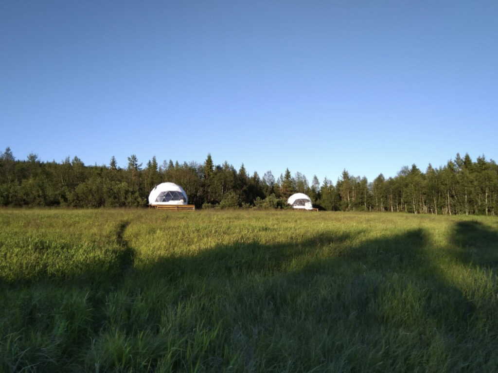 Trysil glamping med to domer i hvit på grønt gress. 