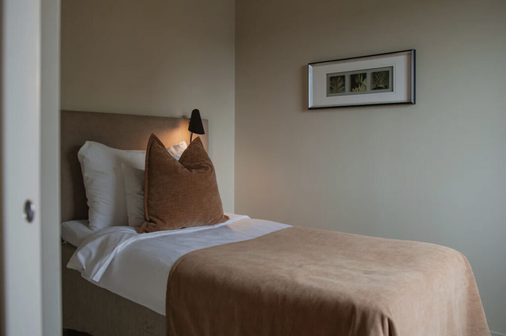 Home Hotel Odin med ekeltseng og bilde på veggen.