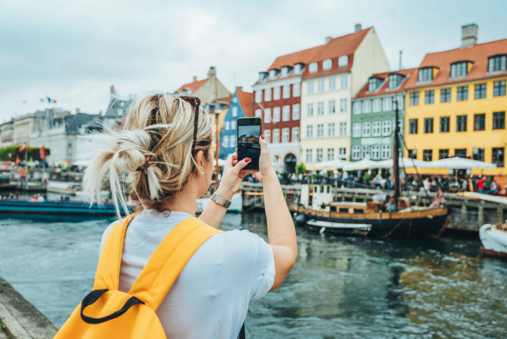 Dame som tar bilde av havnen i København.