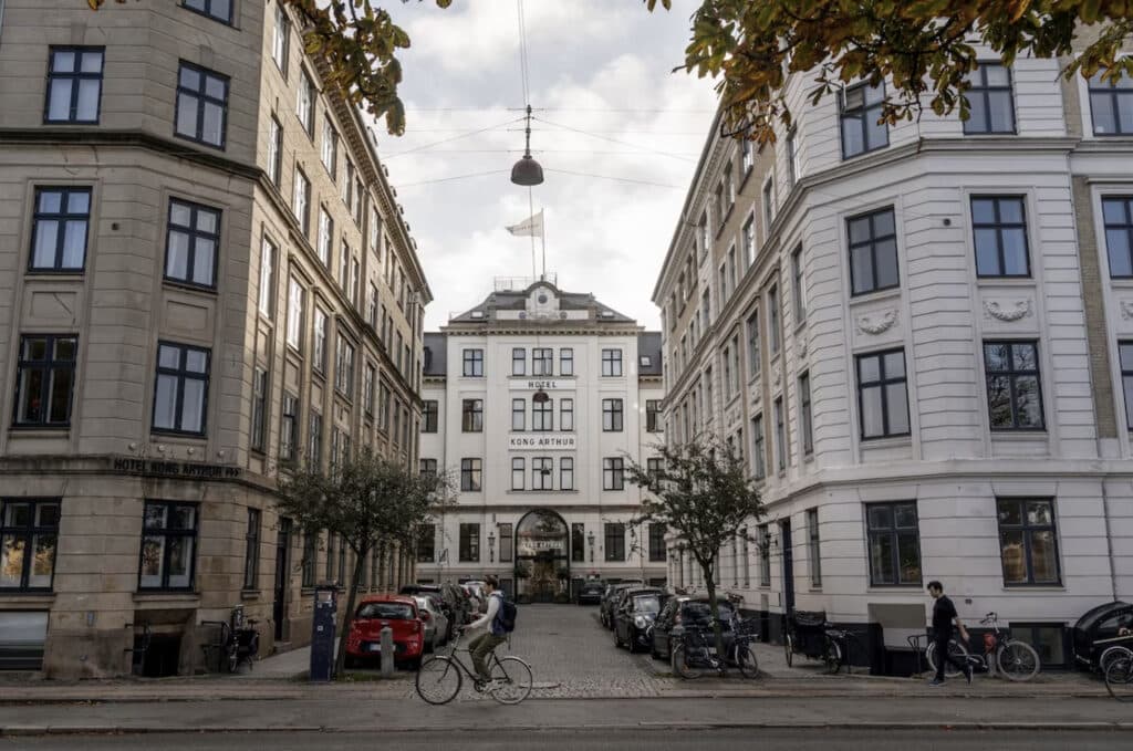 Hotellfasade med en som sykler over veien.