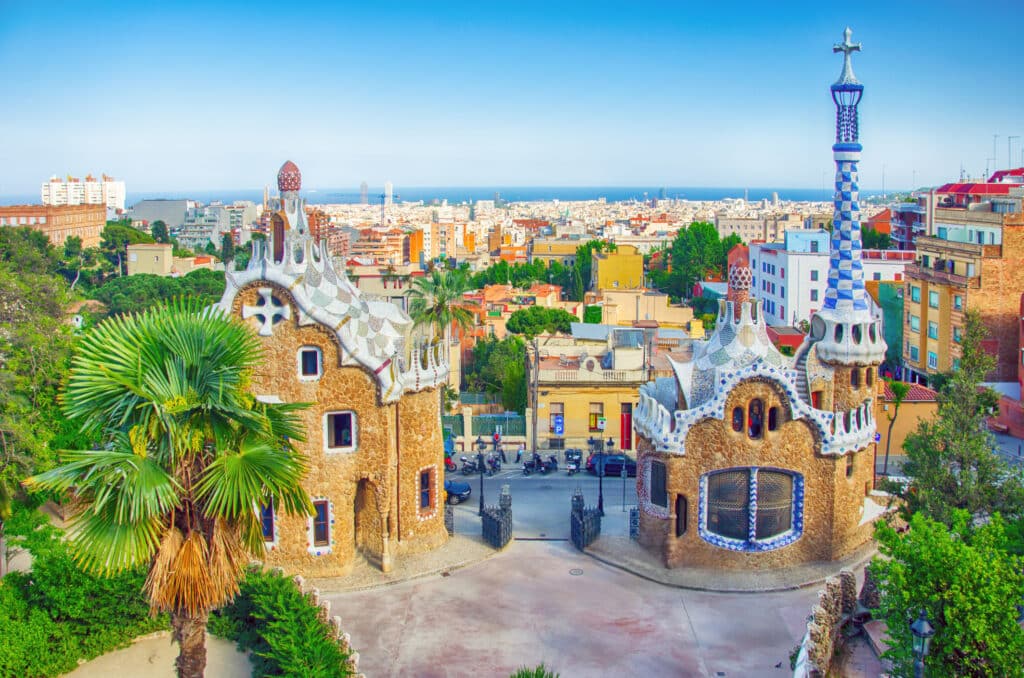 Park Guell med palmetre, bygninger og utsikt over Barcelona by.