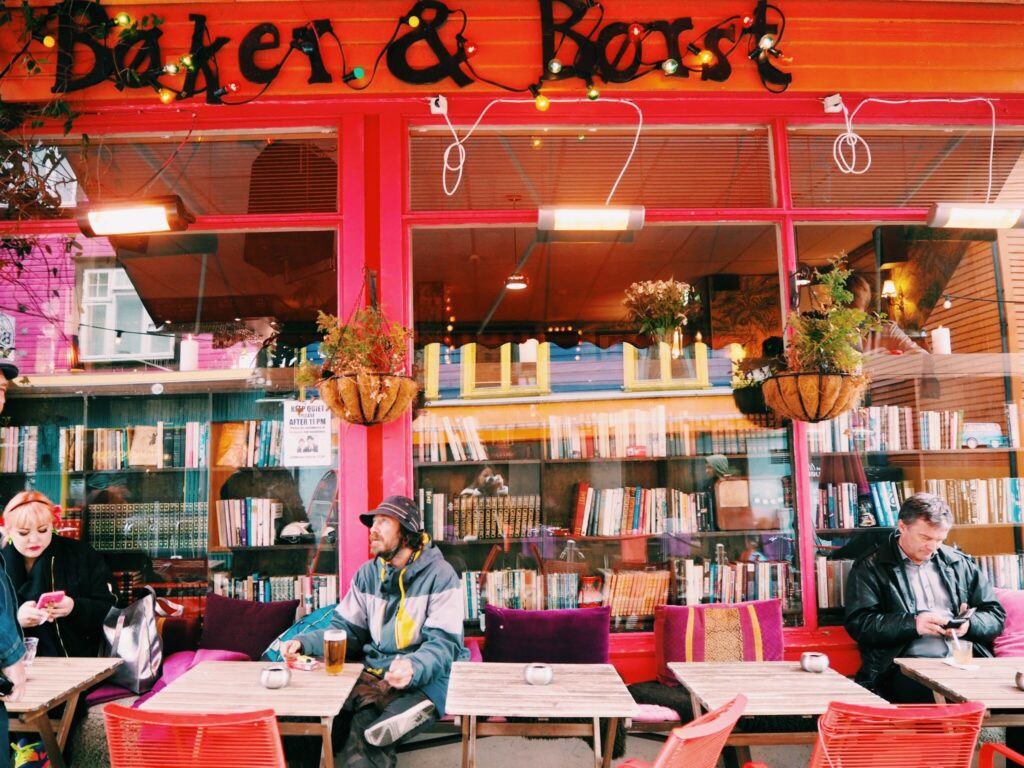 Kafe med bøker og folk som nyter noe godt i glasset.