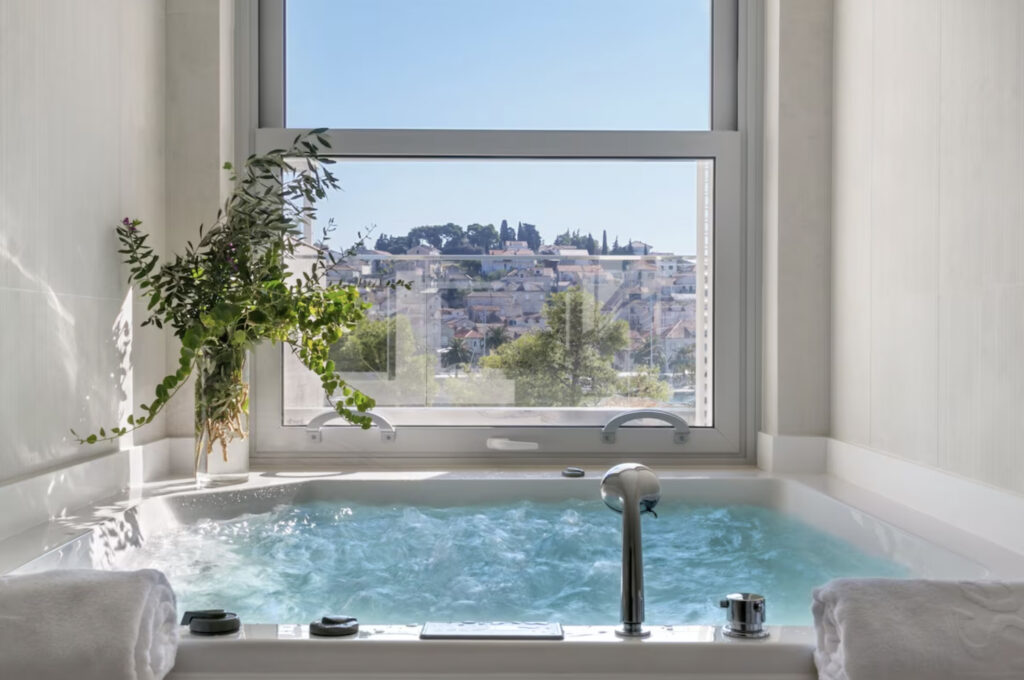 Adriana Hvar Spa Hotel med innendørs boblebad og vindu mot Hvar by.