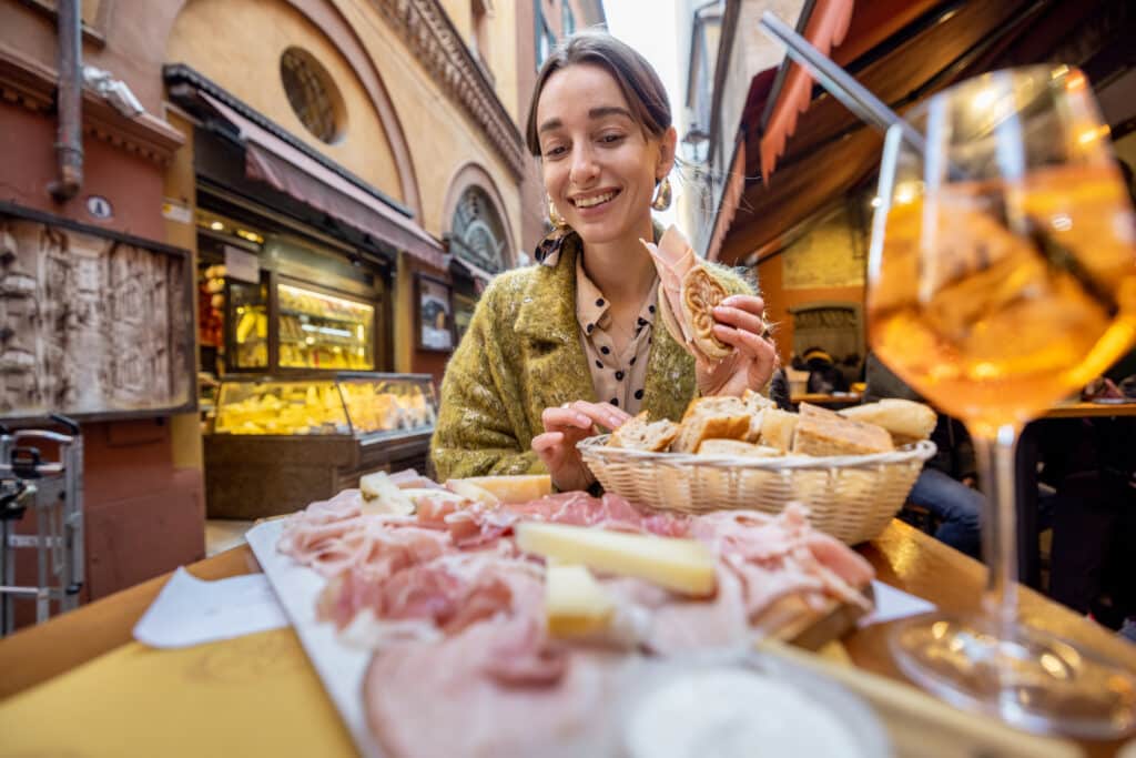 Dame som sitter ute i Bologna og spiser italiensk mat og aperol spritz.