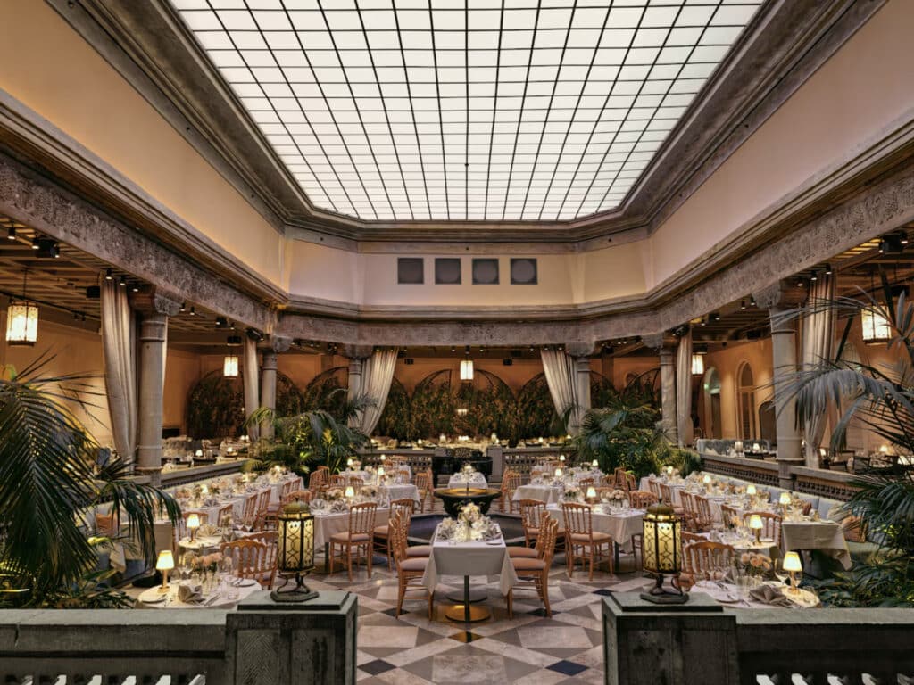 Britannia Hotel restaurant - palmer, bord, stoler og høyt tak.