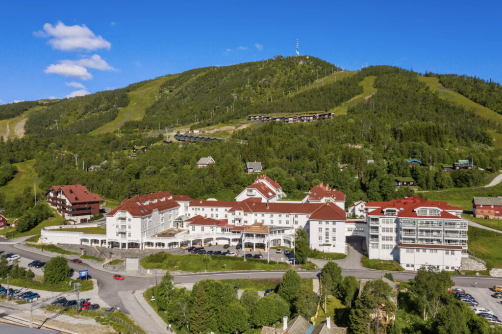 Dr.Holms utenfor med grønt fjell.