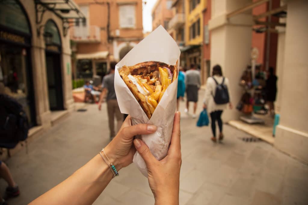 Dame som holder en gyros kebab i Hellas. 