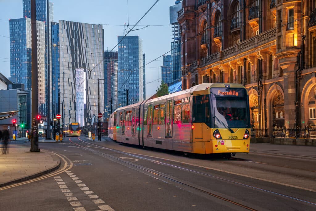 Manchester by med gul trikk og skyskrapere. 