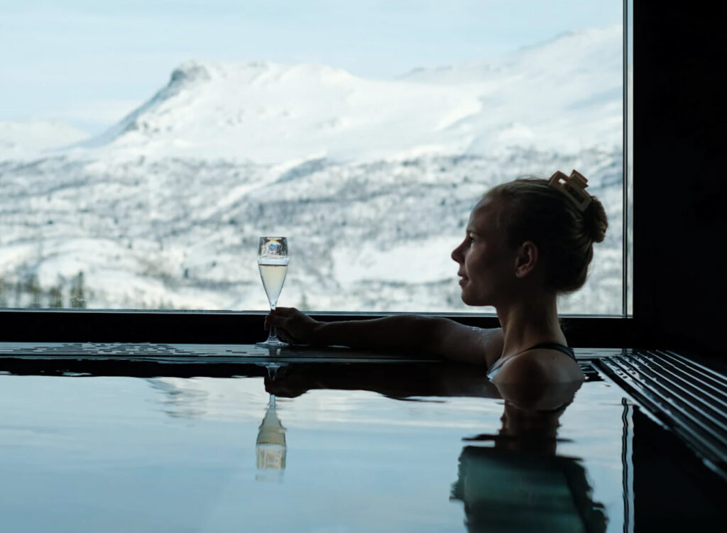Skarsnuten hotell med basseng og utsikt. Dame som nyter et glass bobler.